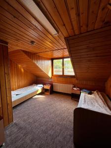 an attic room with two beds and a window at FELIX hostel in Dumbrăveni