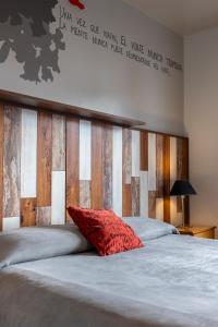 Una cama con una almohada roja encima. en Los Troncos Boutique, en San Carlos de Bariloche