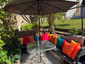 an umbrella over a couch with colorful pillows at Mysig innerstads lägenhet in Visby