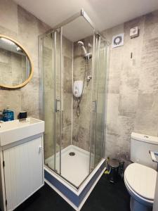a bathroom with a shower with a toilet and a sink at Kingsdowns Top Family Chalet, stunning and cosy interiors, indoor heated pool, mini golf, tennis court, BBQ and beach! in Kingsdown