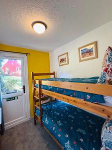 a bedroom with a bunk bed and a window at Kingsdowns Top Family Chalet, stunning and cosy interiors, indoor heated pool, mini golf, tennis court, BBQ and beach! in Kingsdown +33 photos