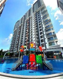 un parque infantil frente a un gran edificio de apartamentos en K Avenue By D Hara Residence, en Kota Kinabalu
