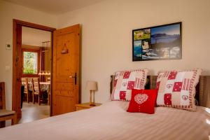 a bedroom with a bed with red and white pillows at Apartment La Tibolire in Sixt