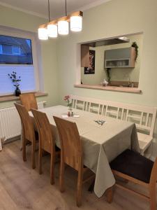Un comedor con una mesa y sillas y un espejo. en Wacholderweg, Ferienhaus, en Schneverdingen