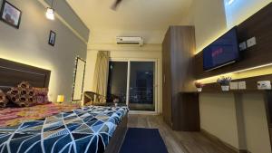 a hotel room with a bed and a television at The Chill Spot in Greater Noida
