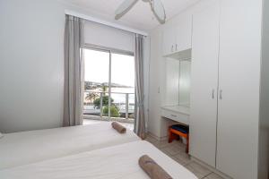 a bedroom with a bed and a large window at Seagull 407 in Margate +8 photos