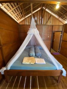 a bed with two pillows and a canopy in a boat at Irene Homestay Raja Ampat in Mios Besar