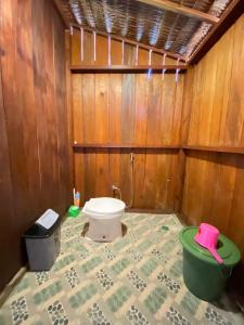 a bathroom with a toilet in a wooden wall at Irene Homestay Raja Ampat in Mios Besar +112 photos