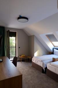 Un dormitorio con dos camas y una mesa y una ventana. en Acacia Hotel, en Sofía
