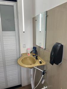 een badkamer met een wastafel en een spiegel bij Casa SaraH!! in Manaus