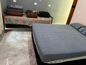 een kamer met een bed en bagage op een tafel bij Casa SaraH!! in Manaus