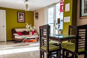 a living room with a table and a couch at Hotel Las Gardenias in Cuenca