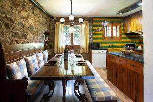 a kitchen with a wooden table with chairs and a counter at Cal Jepet in Pardines