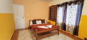 ein kleines Schlafzimmer mit einem Bett und einem Fenster in der Unterkunft Nivriti Cottage Valley View Stay in Udagamandalam