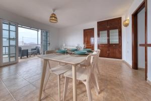 a dining room with a table and chairs at Apartamento El Charcon B - 10 meters to the Beach By Lanzarote Vacation Homes in Arrieta +16 photos