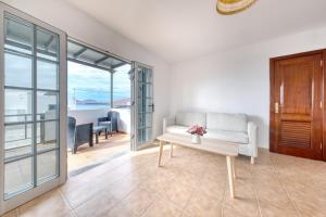 a living room with a couch and a table at Apartamento El Charcon B - 10 meters to the Beach By Lanzarote Vacation Homes in Arrieta