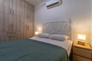 a bedroom with a bed and a tv on the wall at Modern Loutraki Apartment 3min Walk to Beach Fits 4 in Loutraki
