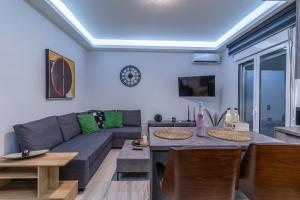 a living room with a couch and a table at Modern Loutraki Apartment 3min Walk to Beach Fits 4 in Loutraki
