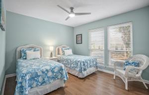a bedroom with two beds and a window at Beautifully Remodeled 3-Bedroom Home with views of the Ocean Point Golf Links in Fripp Island +74 photos