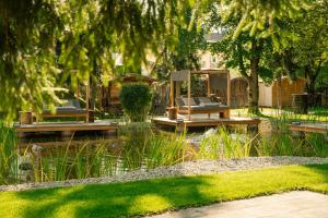 a garden with two benches and a pond at Das Parkhotel - Südtirols nördlichster Punkt in Bad Wörishofen