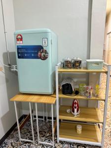 a refrigerator sitting in a kitchen next to a shelf at AHM RoomSTAY in Kuala Terengganu