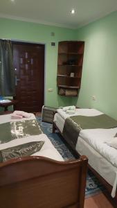 two beds in a room with green walls at Dilbo House in Dilijan