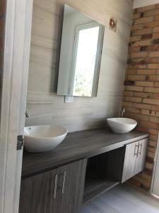 a bathroom with two sinks and a mirror at Hermosa cabaña cerca Restrepo in Villavicencio