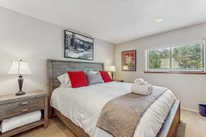 a bedroom with a bed and a nightstand and two windows at Azure Palace in South Lake Tahoe