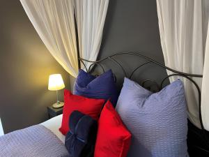 - une chambre avec un lit et des oreillers colorés dans l'établissement Gite Bleu - Paradis de Provence, à Le Pin