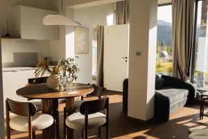 a kitchen and living room with a table and chairs at Stone Suite Zakopane in Zakopane