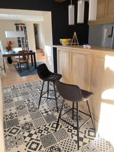 une cuisine avec deux chaises sur un sol carrelé dans l'établissement Gite Bleu - Paradis de Provence, à Le Pin