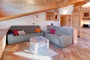 a living room with two couches and a table at Mansarda Combo in Bormio