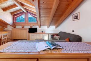 a bedroom with a bed with a book on it at Mansarda Combo in Bormio