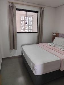 Una habitación blanca con una cama y una ventana en Apartamento 21 Praia de Leste, en Pontal do Paraná