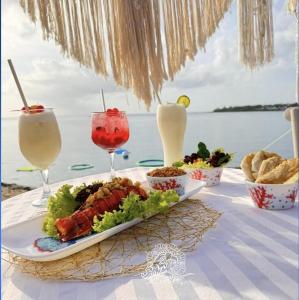 ein Tisch mit einem Teller mit Essen und Getränken in der Unterkunft Hostal San Andres Divers in Gustavo Rojas Pinilla International