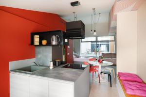 a kitchen with red walls and a table with chairs at Donizetti Studios in Bergamo