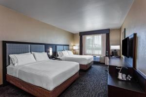 a hotel room with two beds and a flat screen tv at Holiday Inn Express & Suites Anaheim Resort Area, an IHG Hotel in Anaheim