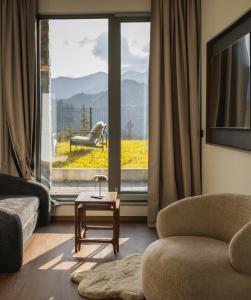 a living room with a couch and a table in front of a window at Stone Suite Zakopane in Zakopane