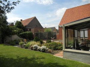 a house with a yard with a garden with flowers at Het Margrietje in Merkem