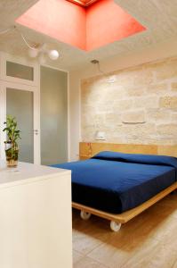 a bedroom with a bed with a blue comforter at Cave Bianche Hotel in Favignana