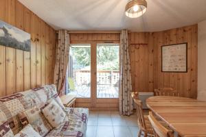 een woonkamer met een bank en een tafel bij L’Edelweiss Pied des Pistes in Morillon