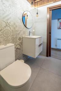 a bathroom with a white toilet and a mirror at Las casitas de mache - MODESTO in Cerler +8 photos