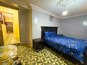 a bedroom with a bed with a blue comforter at vintage in Fez