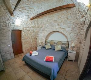 een slaapkamer met een bed in een stenen muur bij Villa with Trullo and Pool, Alberobello in Alberobello
