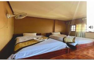 a bedroom with two beds in a room at Spa Queens hotel in Vang Vieng