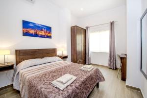 a bedroom with a bed with two towels on it at Seabreeze in Sliema