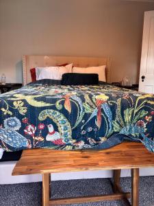 a bed with a colorful blanket on top of it at Farmhouse by Ricketts Glen in Benton
