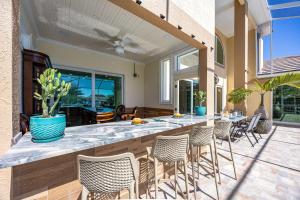 a patio with a bar with chairs and tables at Plunge into Joy & Bayfront Magic at Seaside Escape - Villa Seabird in Apollo Beach