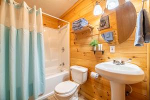 een badkamer met toilet, wastafel en bad bij Haus Edelweiss By Avada Properties in Sevierville +58 foto's
