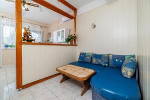 a living room with a blue couch and a table at Apartments Mig in Supetarska Draga